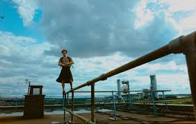 Le personnage de Bird est sur un toit, debout sur un tuyau.